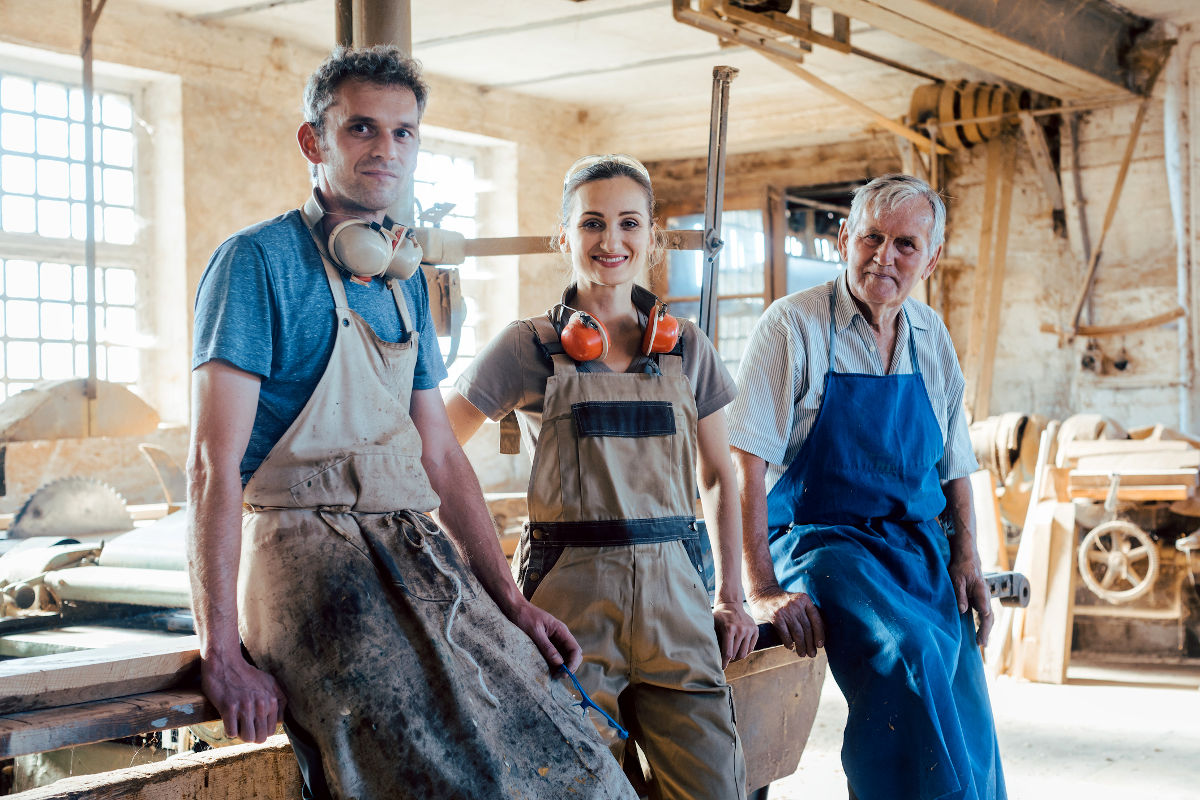 Entreprise familiale de menuisier avec des générations dans l'atelier faisant une pause.